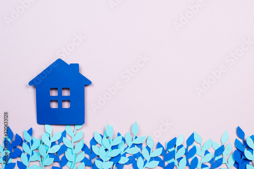 paper blue house with blue paper flowers on a pink background