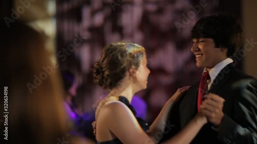 A teenage boy and girl dancing at a senior prom high school dance photo