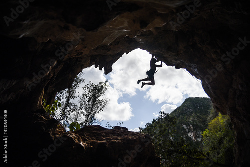 A man rock climbing in a cave. 
