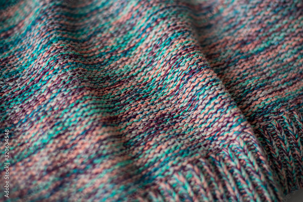 Texture of a cozy vibrant colorful knitted warm sweater fabric