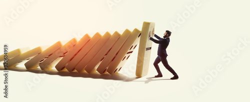 The man stops the falling dominoes. Concept of crisis management.