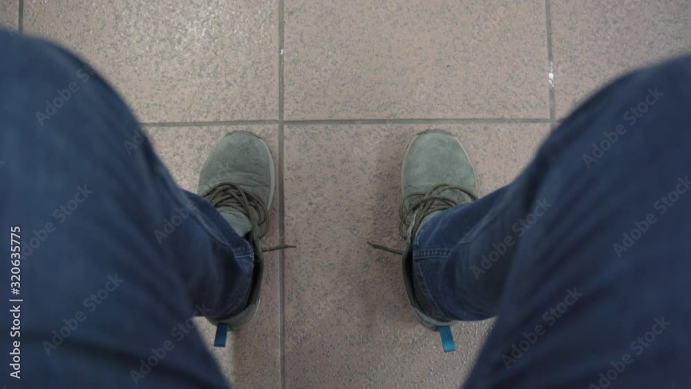 A man sits in sneakers with untied shoelaces and stomps A man sits in sneakers with untied shoelaces and stomps