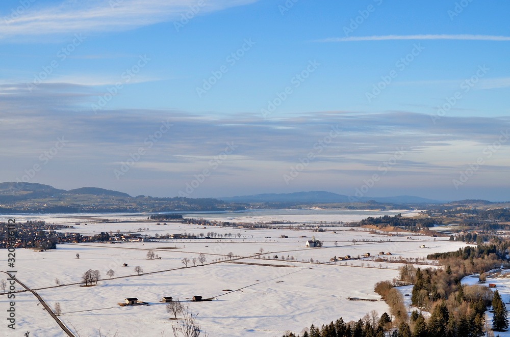 view from Neuschwanstein Castle to the sunny snow-covered valley