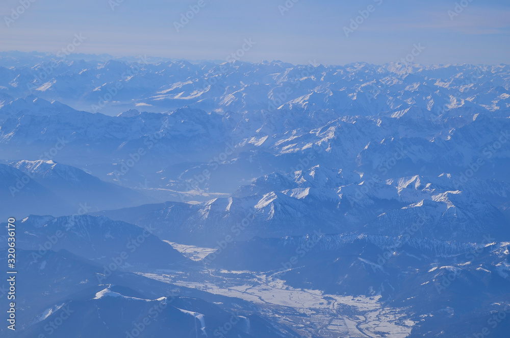 snow-covered German Alps photographed from a plane window