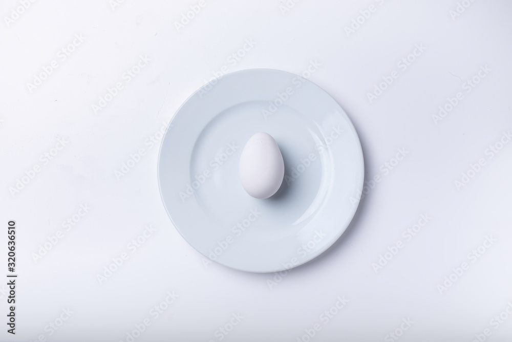 huevo sobre un plato y fondo blanco. huevo sobre un plato y fondo blanco.