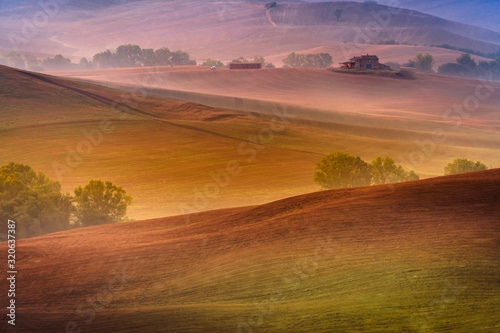 Beautiful wide angle view of Tuscany hills at pink hour sunrise. Travel destination Tuscany, Italy