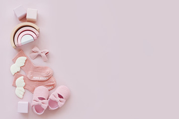 Pink socks, shoes and toys. Set of baby stuff and accessories for girl on pastel background. Baby shower concept.  Fashion newborn. Flat lay, top view