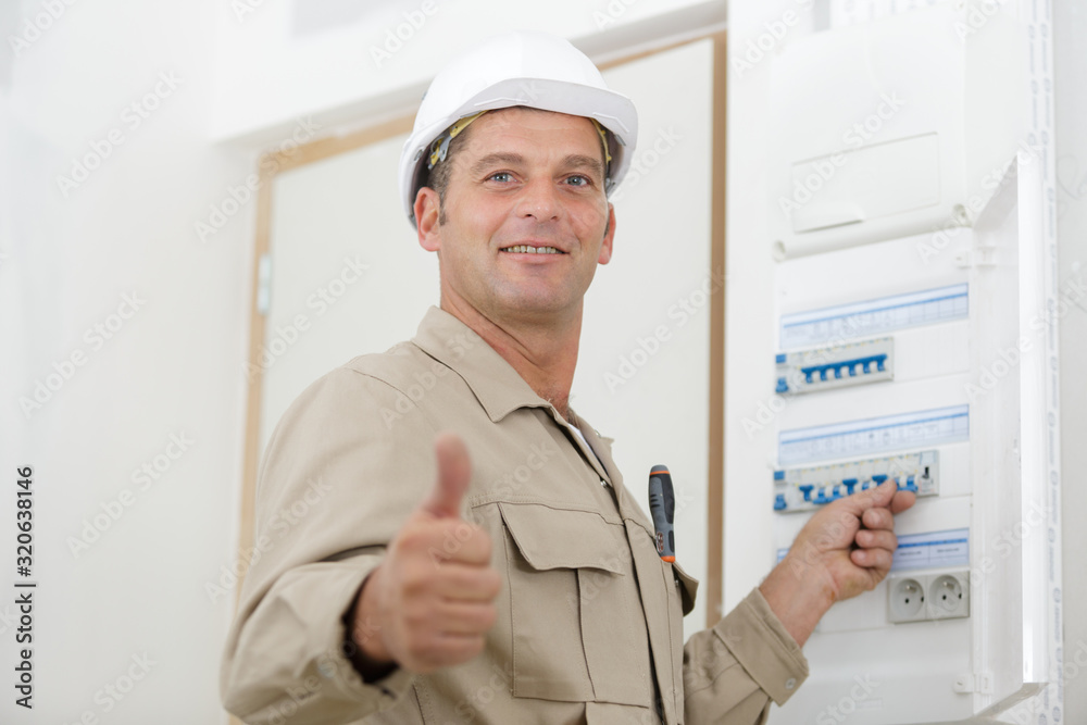 man pressing button on electrical dashboard man pressing button on electrical dashboard