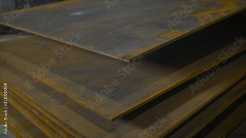 Thick steel sheets are at the factory. Heavy industry. Steel sheets are stacked.