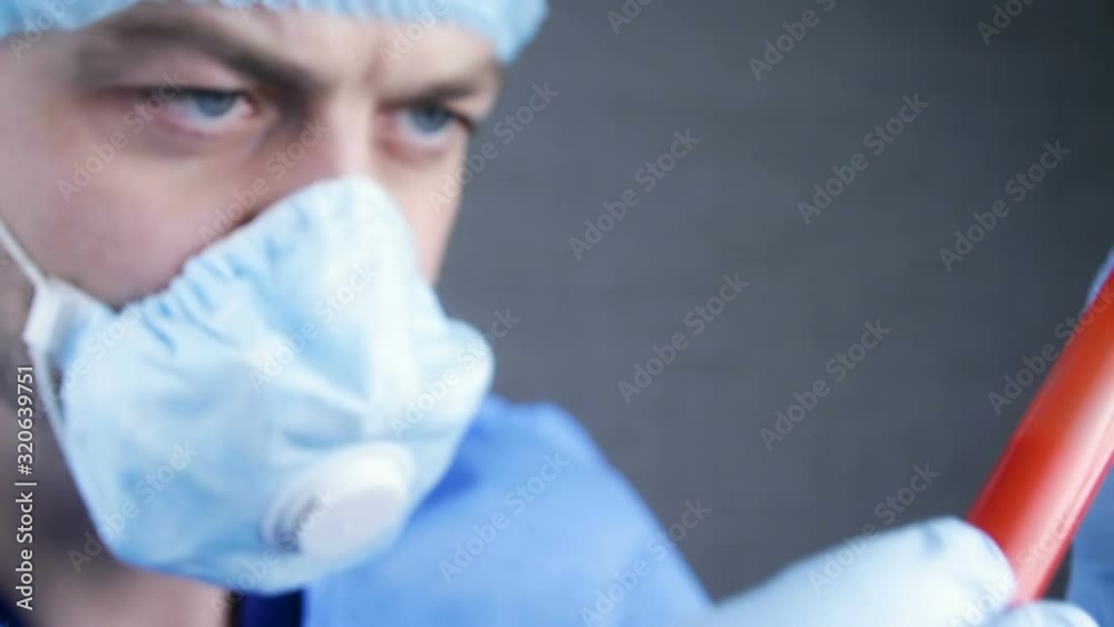 Medical lab worker with protective gloves holding testing blood samples on hospital . Doctor holding test tube with Positive Coronavirus test blood sample. Novel coronavirus (2019-nCoV). Wuhan, China Medical lab worker with protective gloves holding testing blood samples on hospital . Doctor holding test tube with Positive Coronavirus test blood sample. Novel coronavirus (2019-nCoV). Wuhan, China