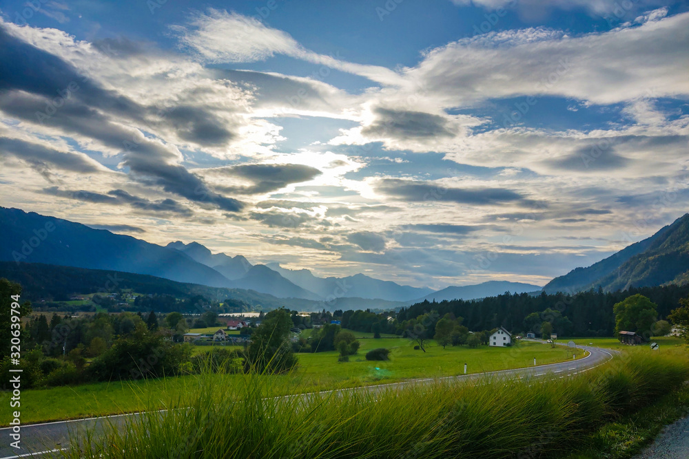 Obraz premium Beautiful view of a green park in spring or summer, blue sky with white clouds.
