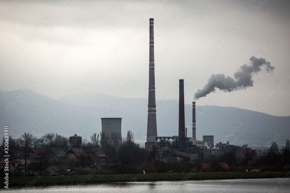 View from afar the city and a factory chimney with lots of smoke and smog. Europe, landscape Slovakia, Novaky. Chemical factory. Abstract. Global warming of the earth. View from afar the city and a factory chimney with lots of smoke and smog. Europe, landscape Slovakia, Novaky. Chemical factory. Abstract. Global warming of the earth.