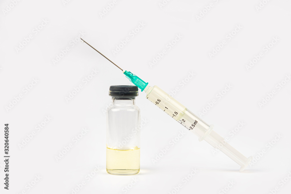 Medical syringe and yellow antibiotic ampoule on a white background Medical syringe and yellow antibiotic ampoule on a white background
