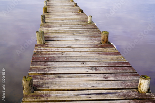 wooden detail background pontoon on water lake with mirror image of sky