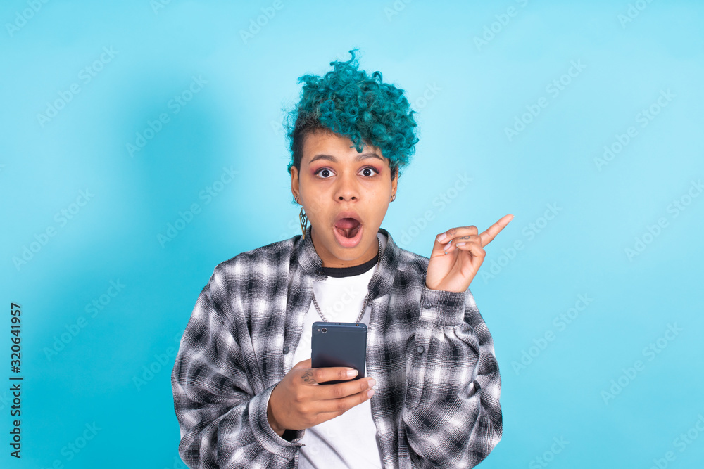 african american girl or woman with mobile phone or smartphone isolated on blue background african american girl or woman with mobile phone or smartphone isolated on blue background