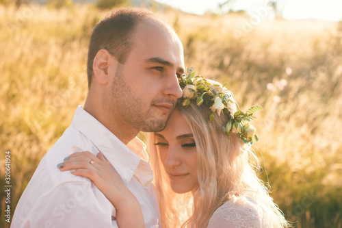 Back view on bride and groom holding hands in sunny summer day. Outdoor wedding and relationsheep romantic concept photo