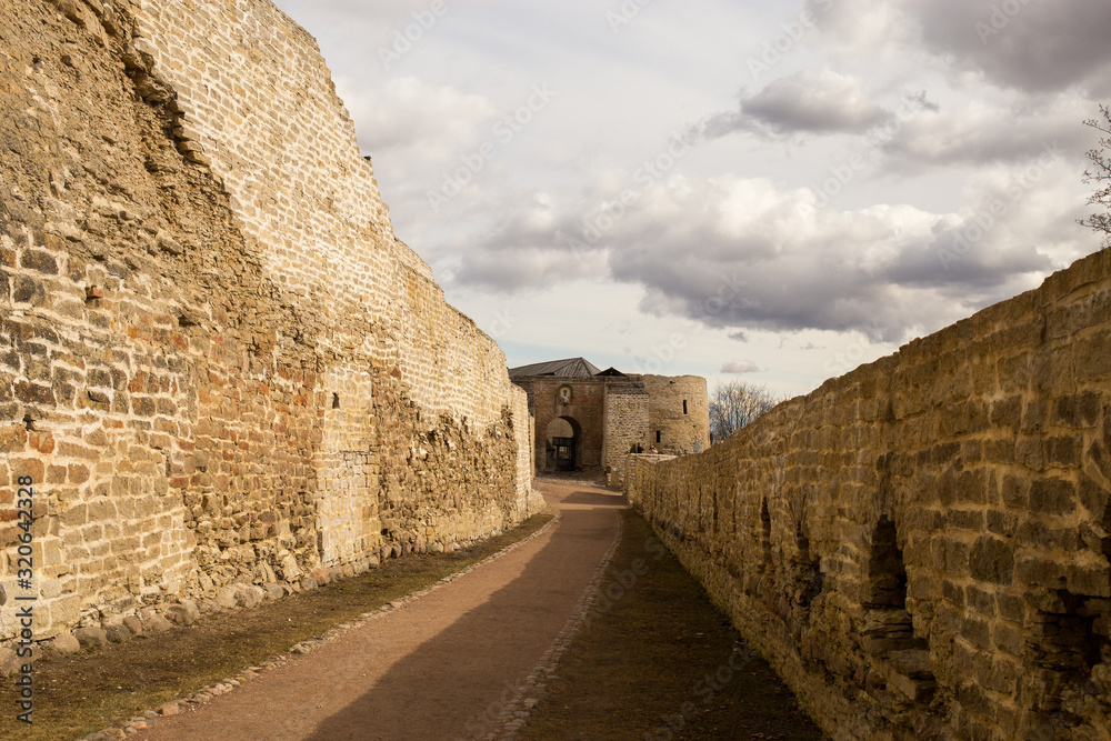 The panorama of the medieval fortress was made on a cloudy spring day. Izborsk, Pskov Region, Russia.