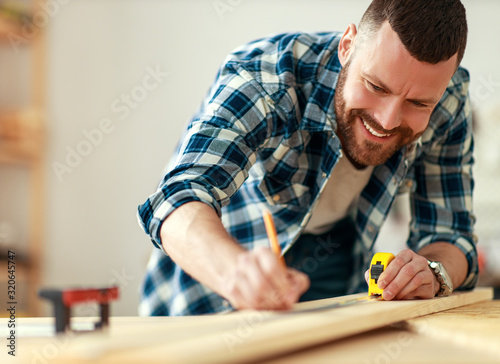 young male carpenter working in workshop.