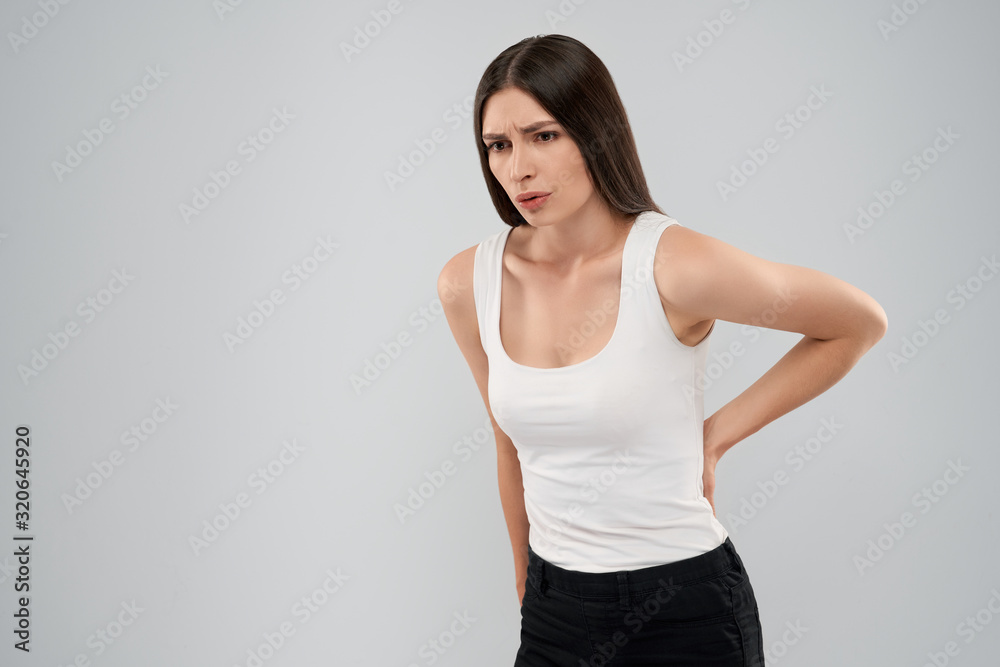 Woman showing pain in back. Woman showing pain in back.