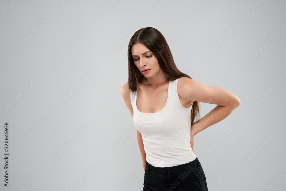 Woman showing pain in back. Woman showing pain in back.