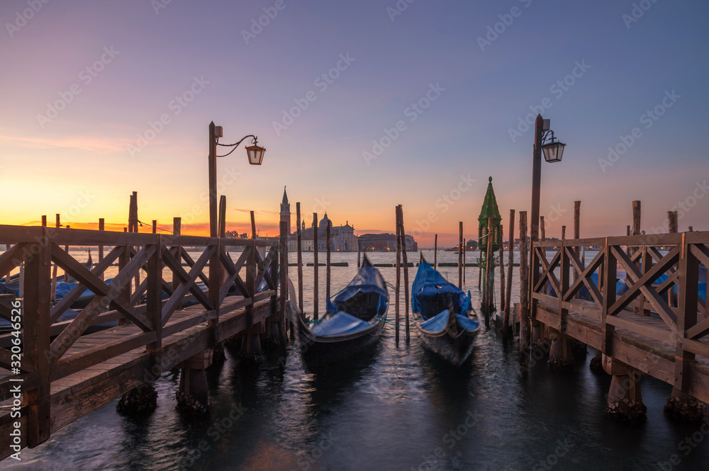 famous gondolas at sunrise. Venice, Italy. picture with long exposure
