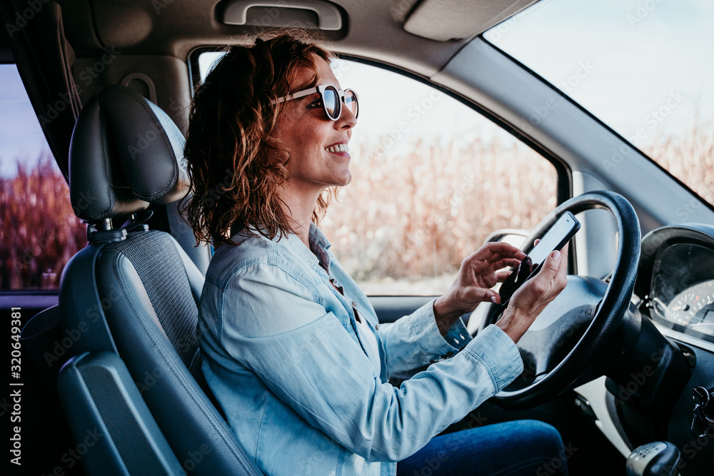 young beautiful woman using mobile phone in a car. travel concept young beautiful woman using mobile phone in a car. travel concept