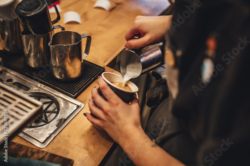 Barista making cappuccion coffee in coffee shop