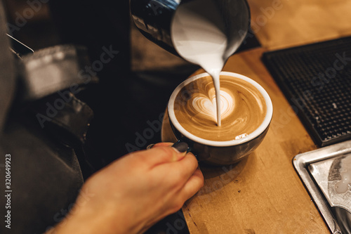 Barista making cappuccion coffee in coffee shop photo