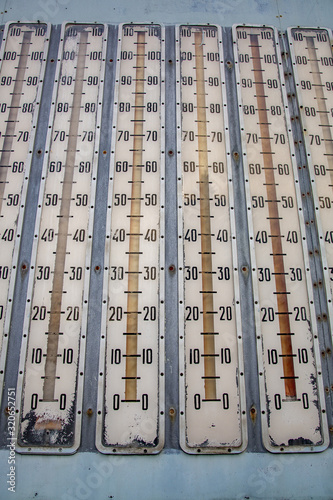 Row of street vintage thermometers with numbers on the scale