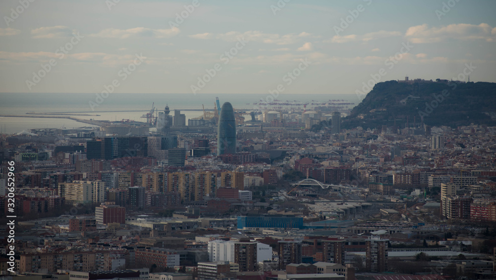 views of barcelona with the aigbar tower and the port in the background