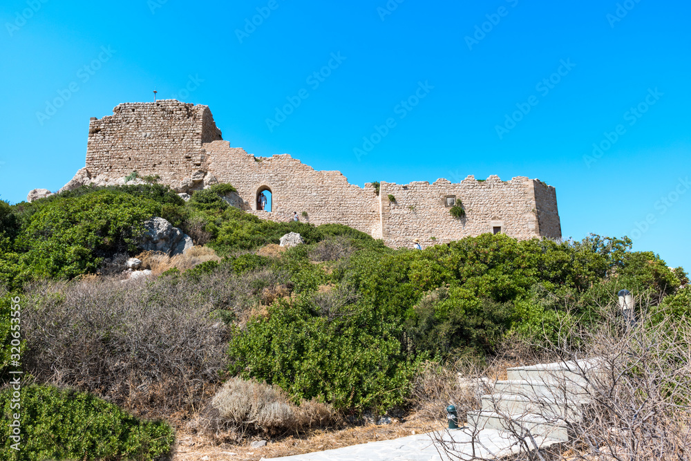 Stairs through bushes to ruins of medieval castle Kritinia (Rhodes, Greece)