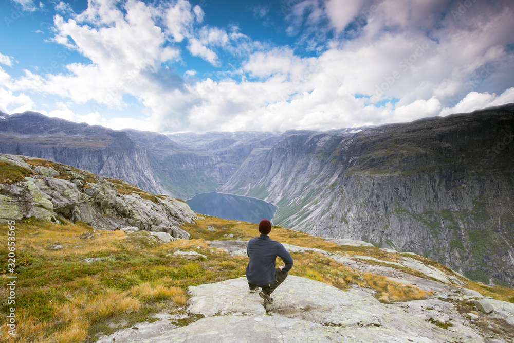 Couple tourist standing against amazing view, beautiful nature landscape hiking in Norway Trolltunga scandinavian