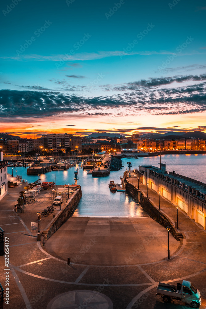 Fototapeta premium The sun rises at dawn from the port of San Sebastian city. Basque Country