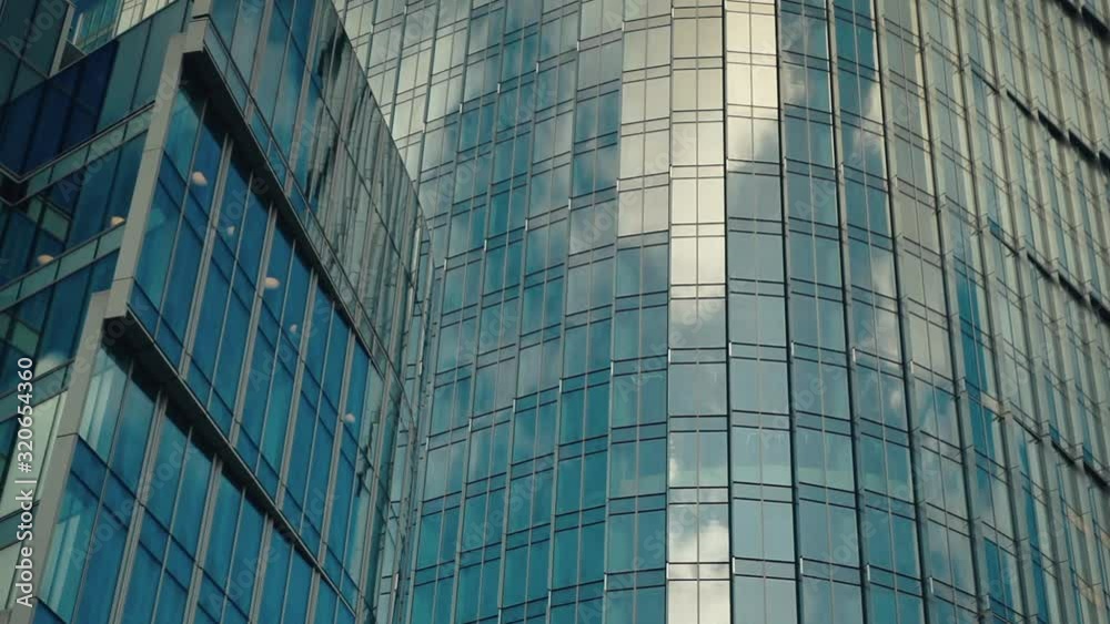 Time lapse of clouds reflecting onto the glass of a large office building. Modern Business Office Buildings with Glass Reflection. 
