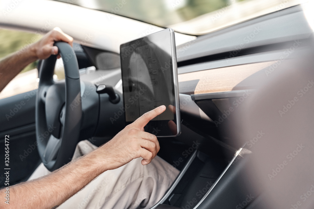 Young adult man adjusting interface system in car Young adult man adjusting interface system in car