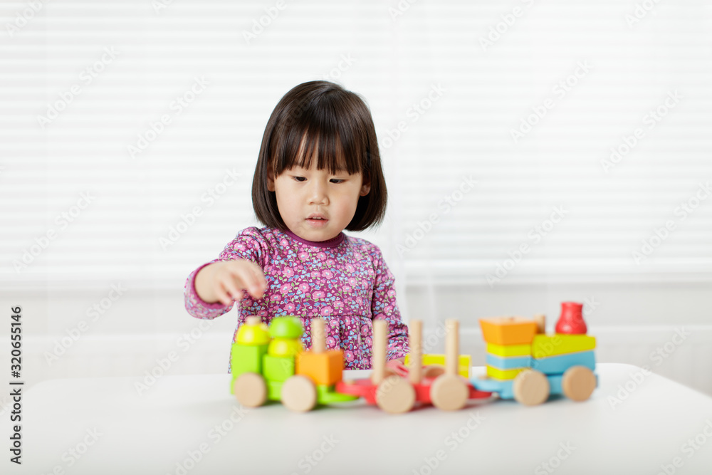 toddler girl playing creative toy blocks at home against white background toddler girl playing creative toy blocks at home against white background