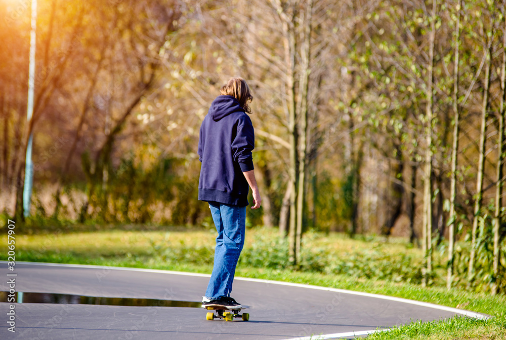 Guy rides a skateboard in the autumn Park