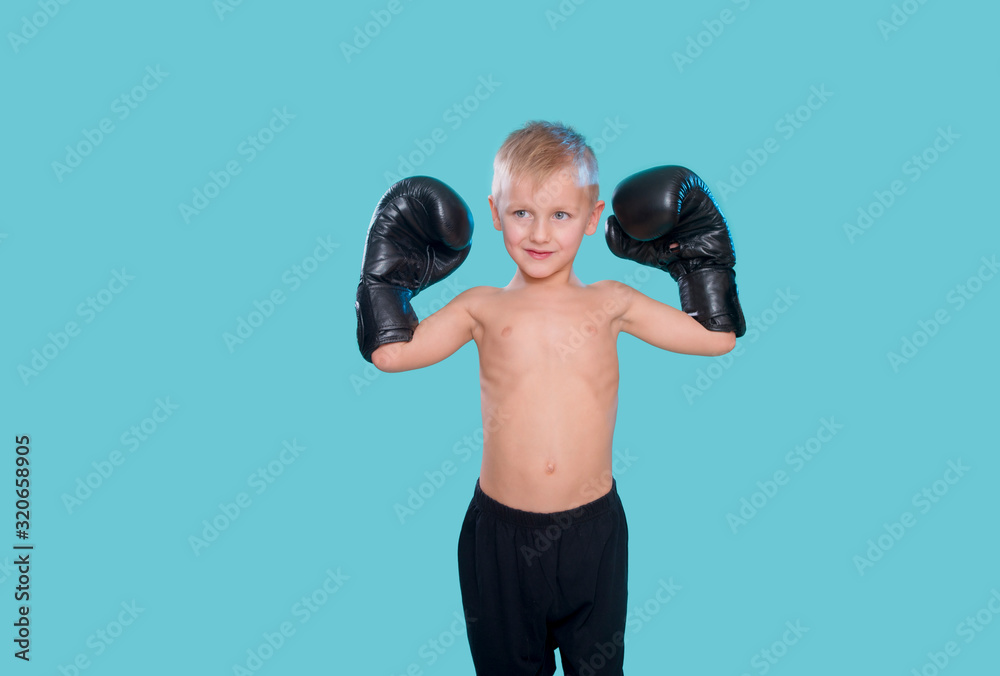 Happy little kid with black boxing gloves
