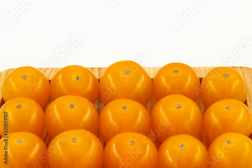 Yellow cherry tomatoes on wooden background close-up