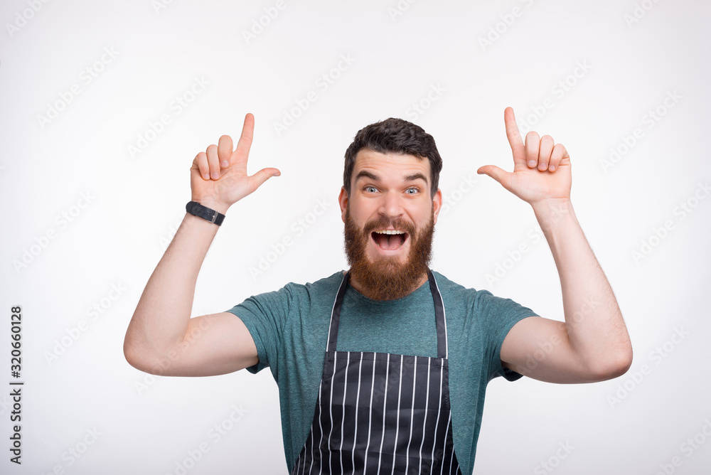 Photo of amazed bearded Chef pointing at copyspace over white background Photo of amazed bearded Chef pointing at copyspace over white background
