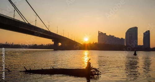 Sunset over the river on the background of the bridge