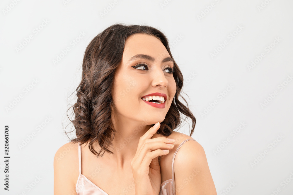 Beautiful young woman with stylish makeup on light background Beautiful young woman with stylish makeup on light background