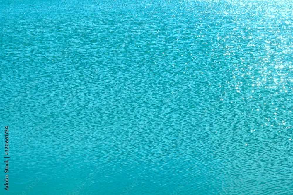 Blurry image of calm blue water texture. Abstract nature texture background. Cropped shot of an ocean. Water, travel, nature concept.