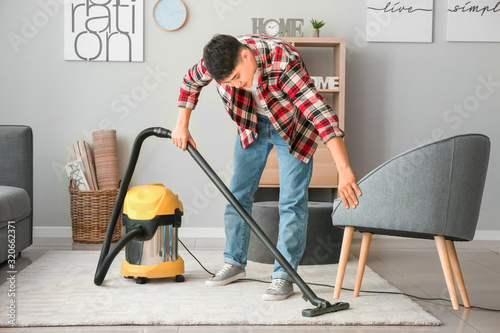 Young Asian man hoovering f...