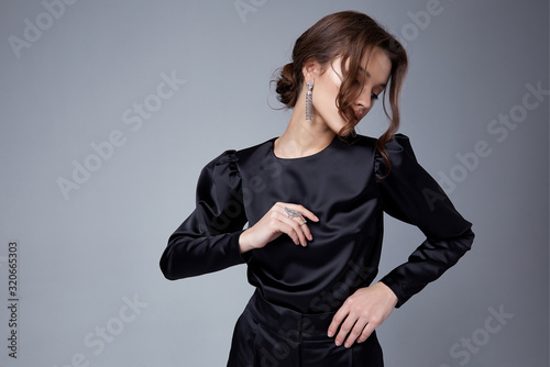 Sexy beautiful woman fashion glamour model brunette hair makeup wear black suit trousers jacket clothes office dress code casual party style accessory date walk girl skinny body shape studio.
