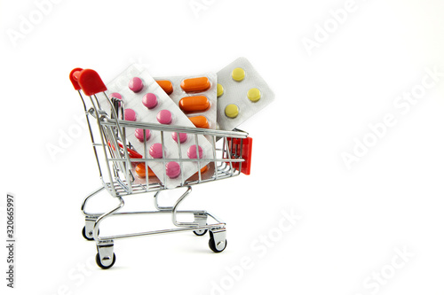 Medical concept. Various pills, pills and capsules in a shopping cart on a white background. Buying medicine. Buying and selling tablets and pills. Place for text