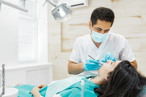 Cute young girl is being examined by the dentist