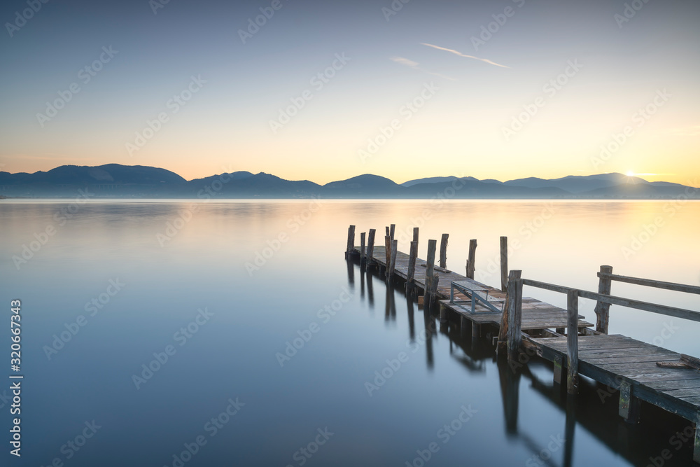 Wooden pier or jetty and lake at sunrise. Torre del lago Puccini Versilia Tuscany, Italy