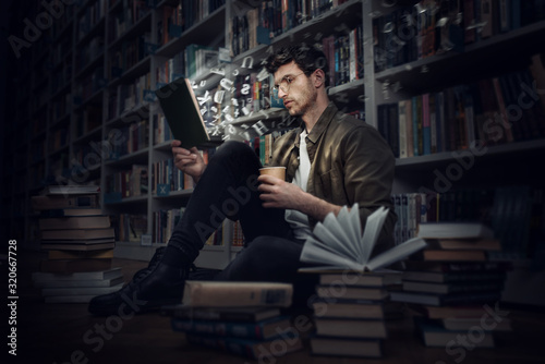 Boy reads a book in a library. Concept of curiosity, imagination and culture photo