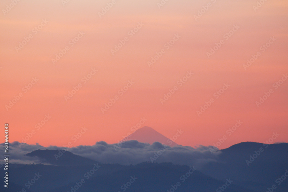 Silhouettes of mountains with clouds and volcano in the background - A view of the volcanoes of Guatemala - Sunset between mountains